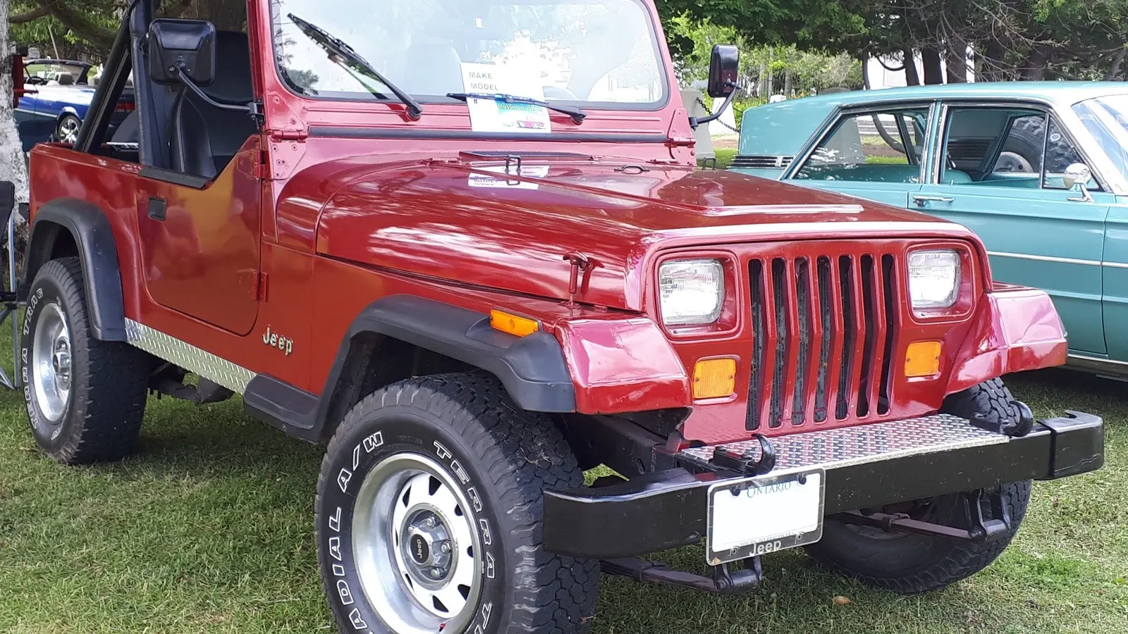 Jeep Wrangler YJ (first generation) in red, front three-quarter view showing the YJ-only square headlamps