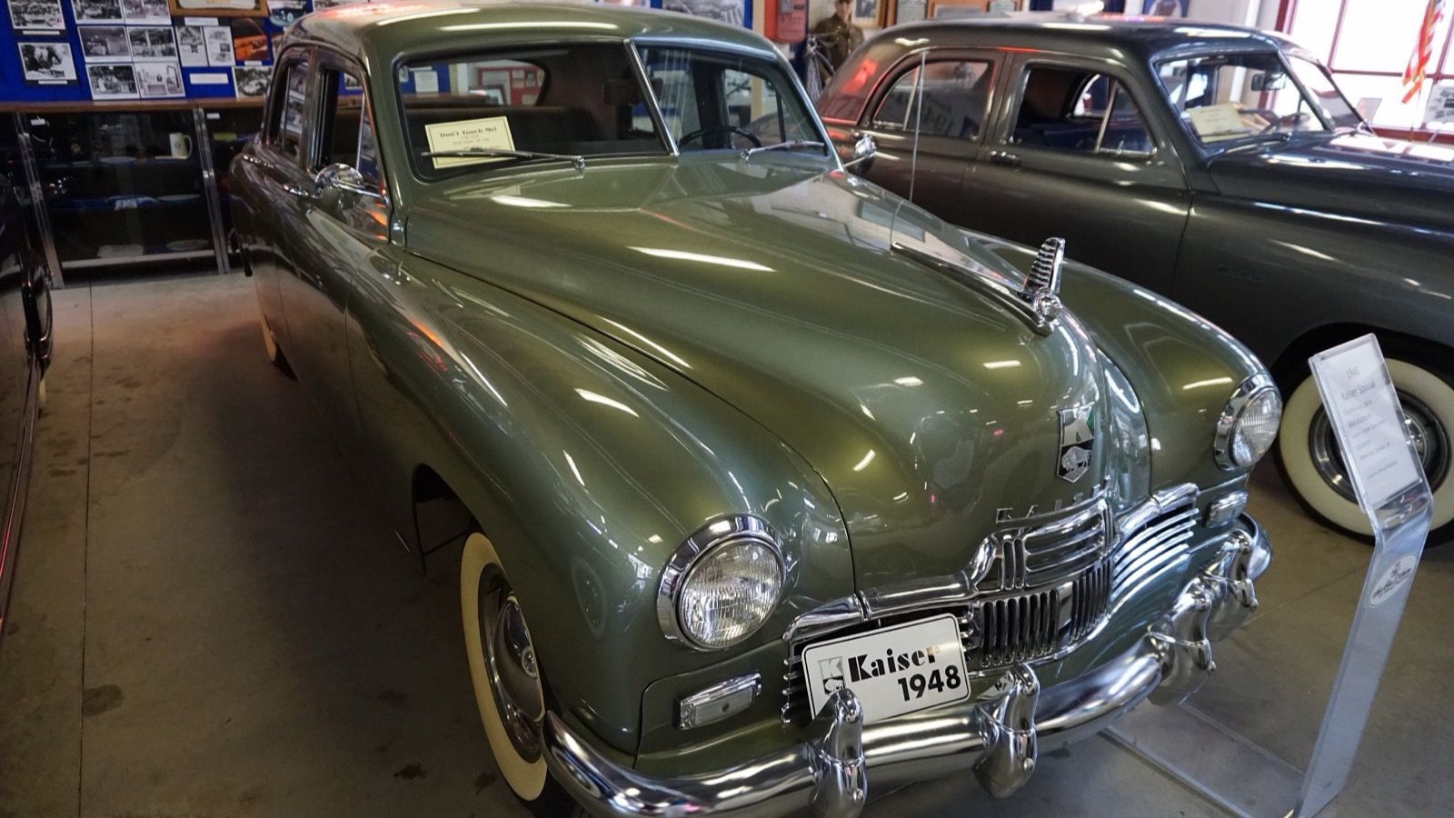 Green 1948 Kaiser Special sedan on museum display, front three-quarter view