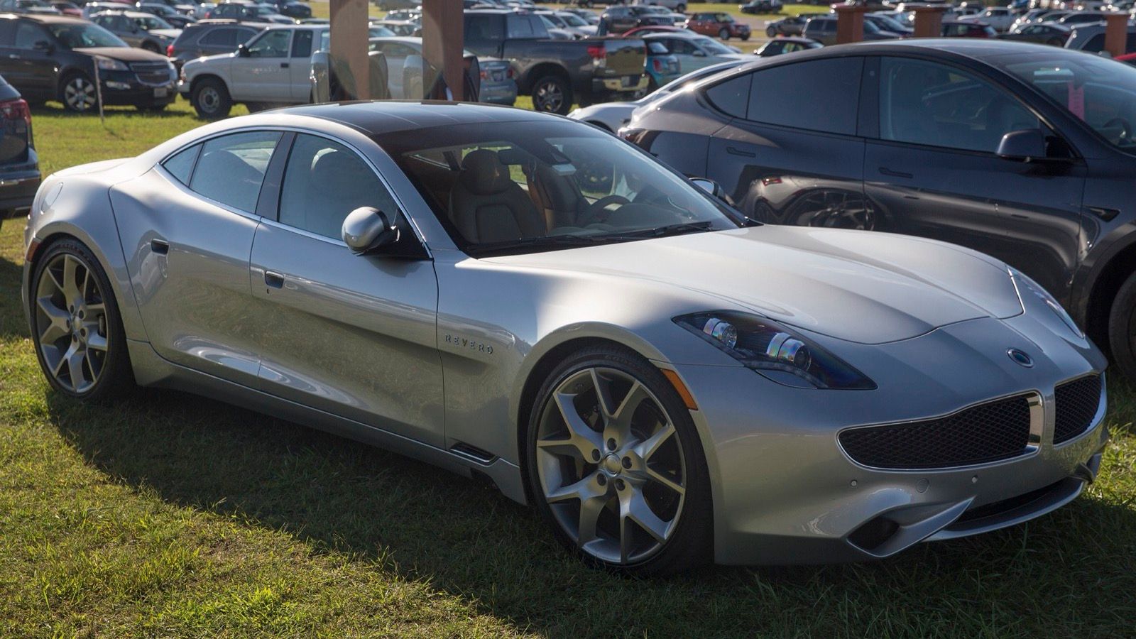 Silver 2019 Karma Revero parked on grass at Lime Rock, front three-quarter view