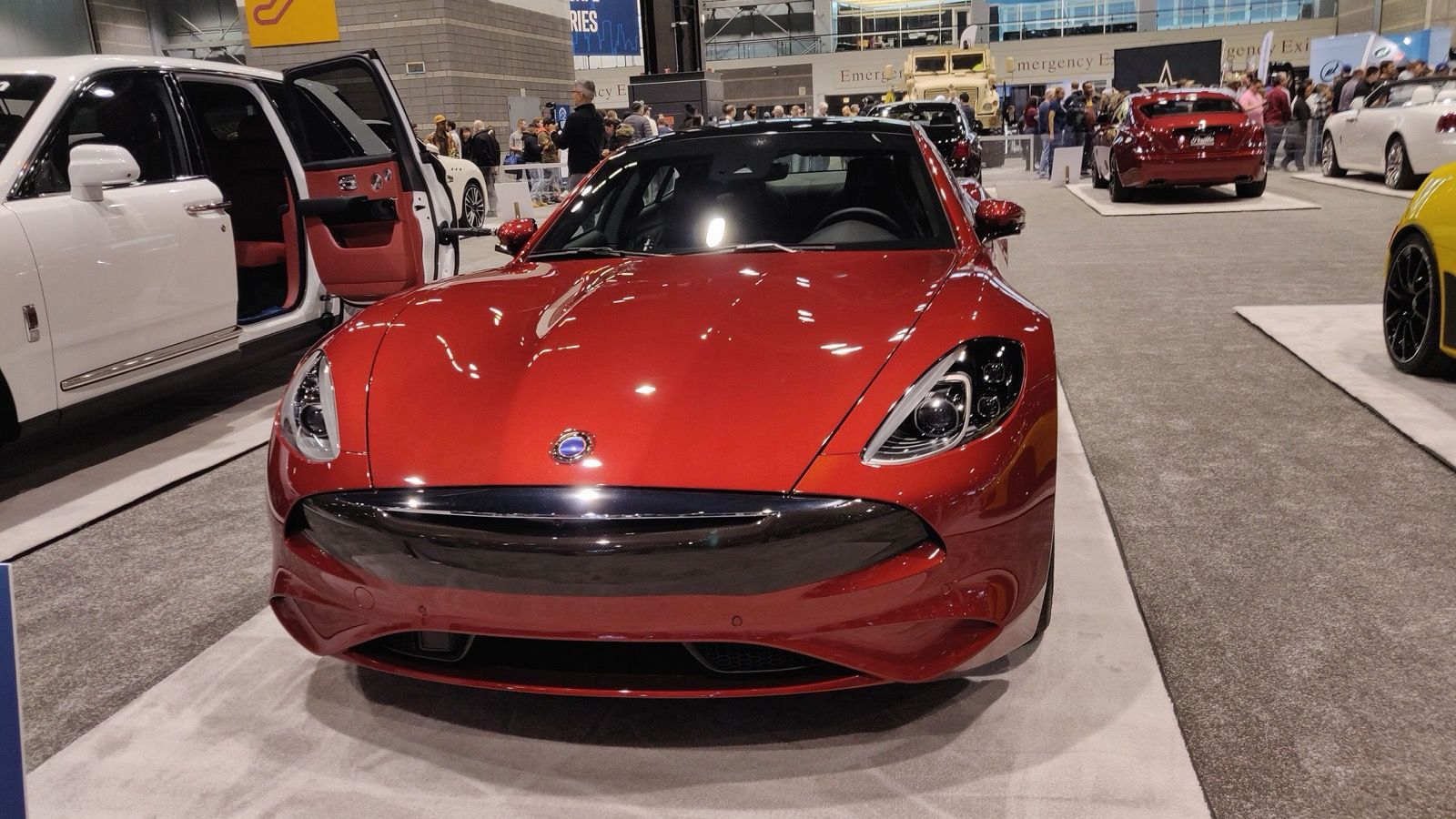 Red 2020 Karma Revero GT on an auto show stand, front view showing the revised fascia