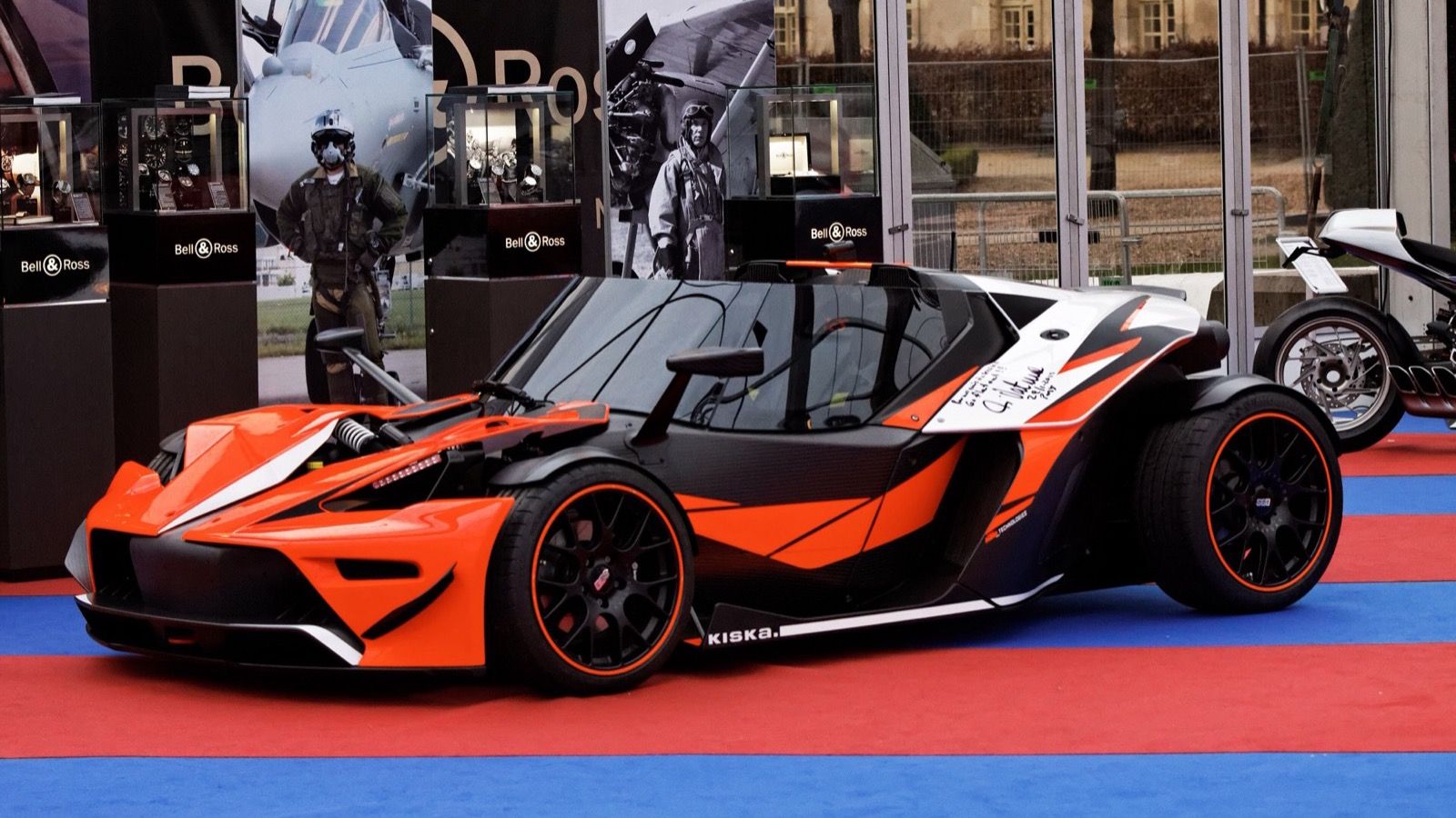 Orange and carbon KTM X-Bow on display at the 2013 Festival Automobile International, front three-quarter view