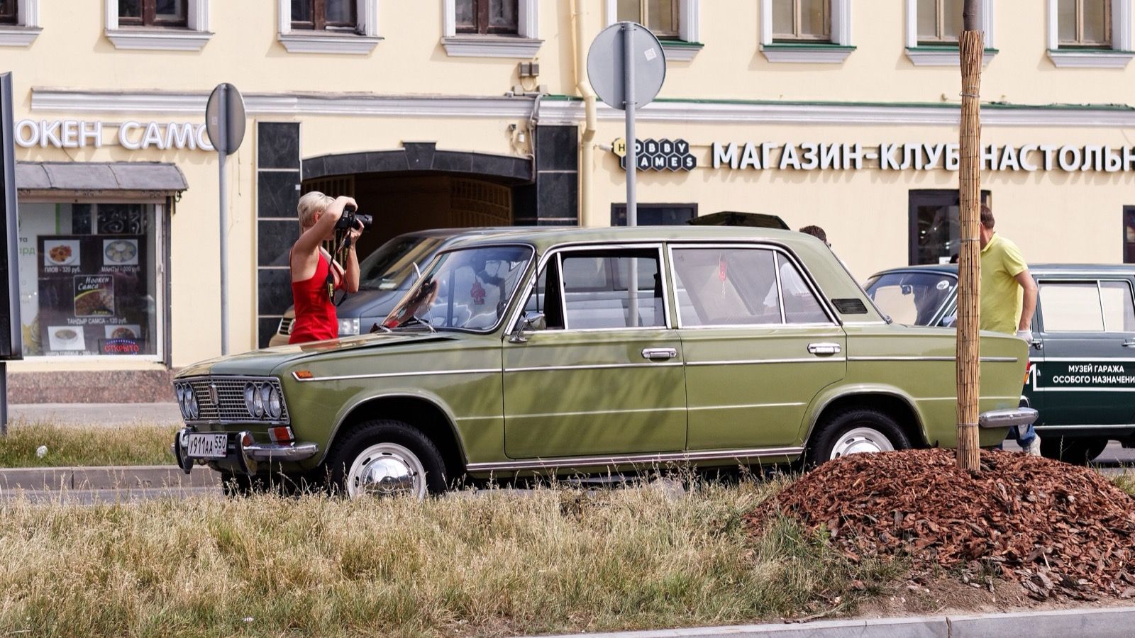 Olive green Lada VAZ-2103 four-door saloon parked on a Moscow street, side profile