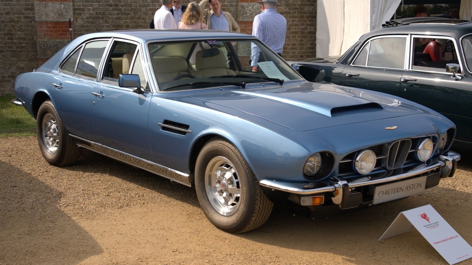 Light blue 1974 Aston Martin Lagonda Series 1 saloon at a concours, front three-quarter view