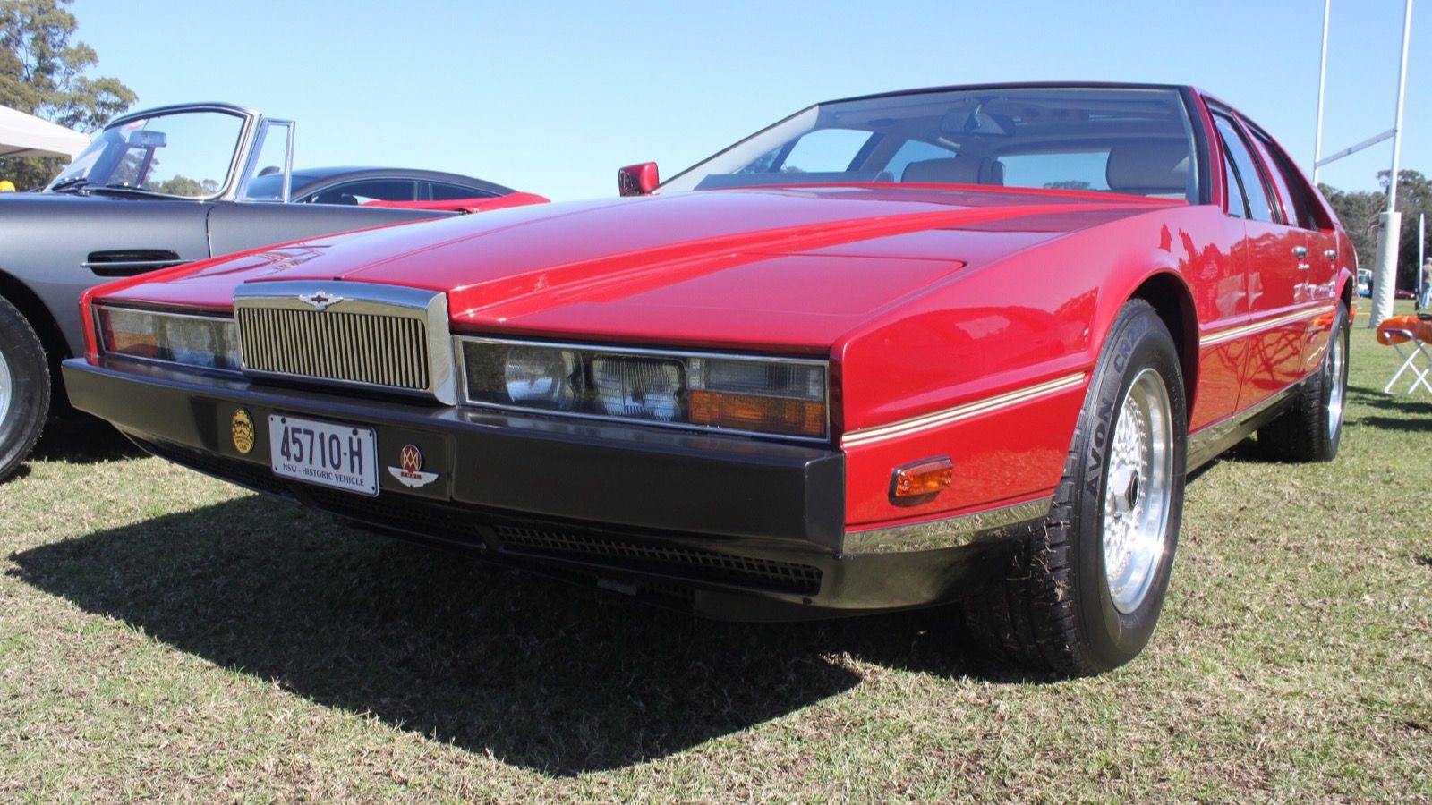 Red 1981 Aston Martin Lagonda wedge saloon at a car show, front three-quarter view