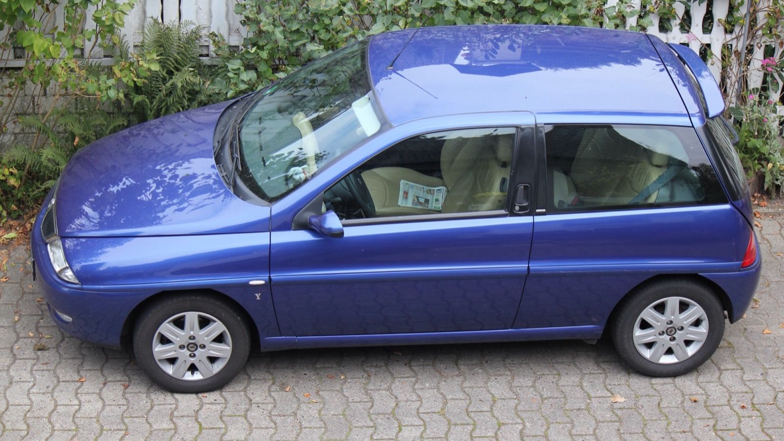 Blue 2002 Lancia Y Cosmopolitan three-door hatchback, side profile view