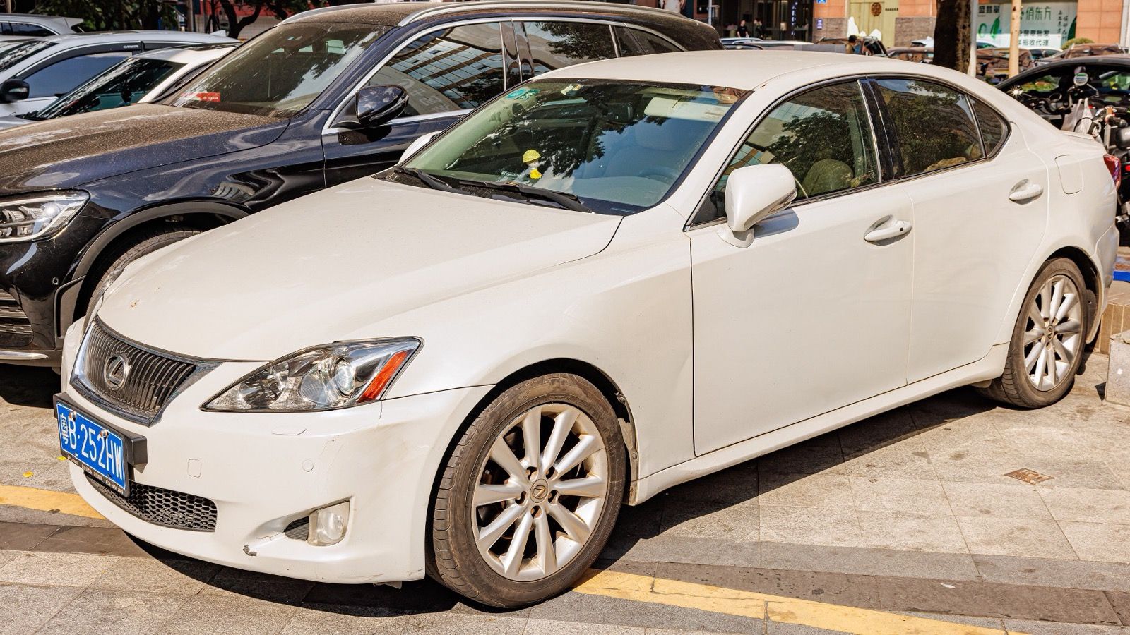 White second-generation Lexus IS sedan parked, front three-quarter view