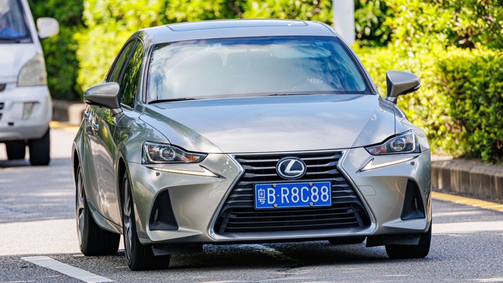 Silver third-generation Lexus IS sedan on the road, front three-quarter view