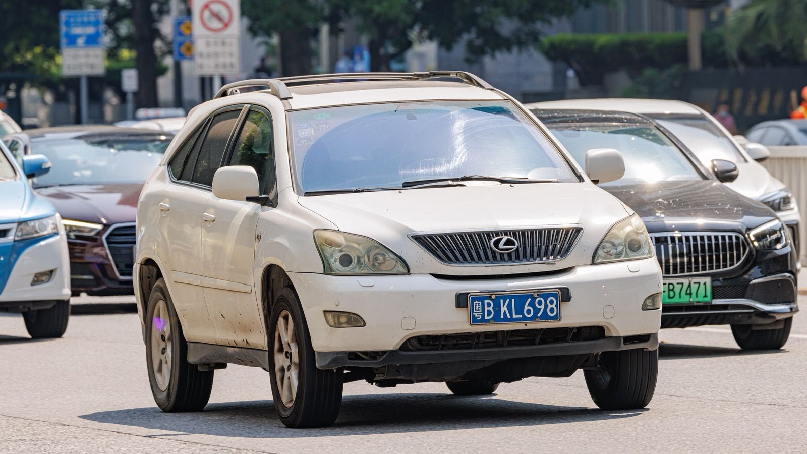 White second-generation Lexus RX crossover in traffic, front three-quarter view