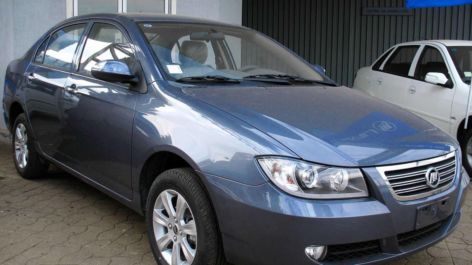 Blue-grey Lifan 620 Solano sedan at a dealership, front three-quarter view