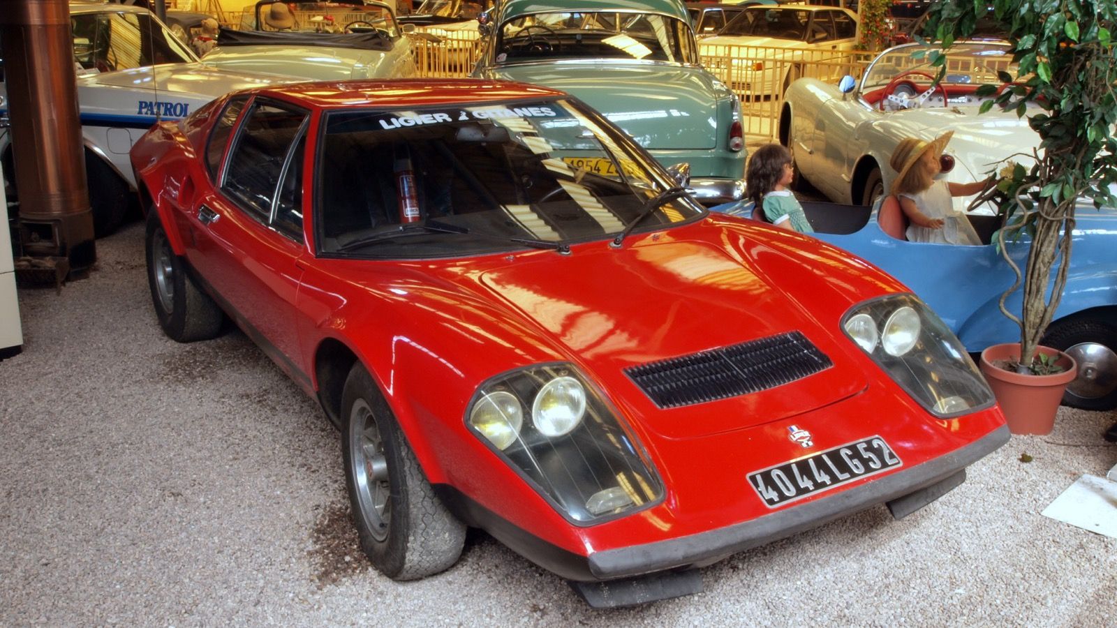 Red 1974 Ligier JS2 on museum display, front three-quarter view