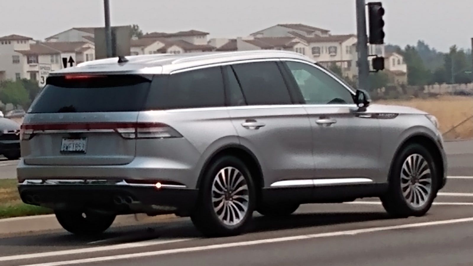 Silver Lincoln Aviator, rear three-quarter view on a suburban road