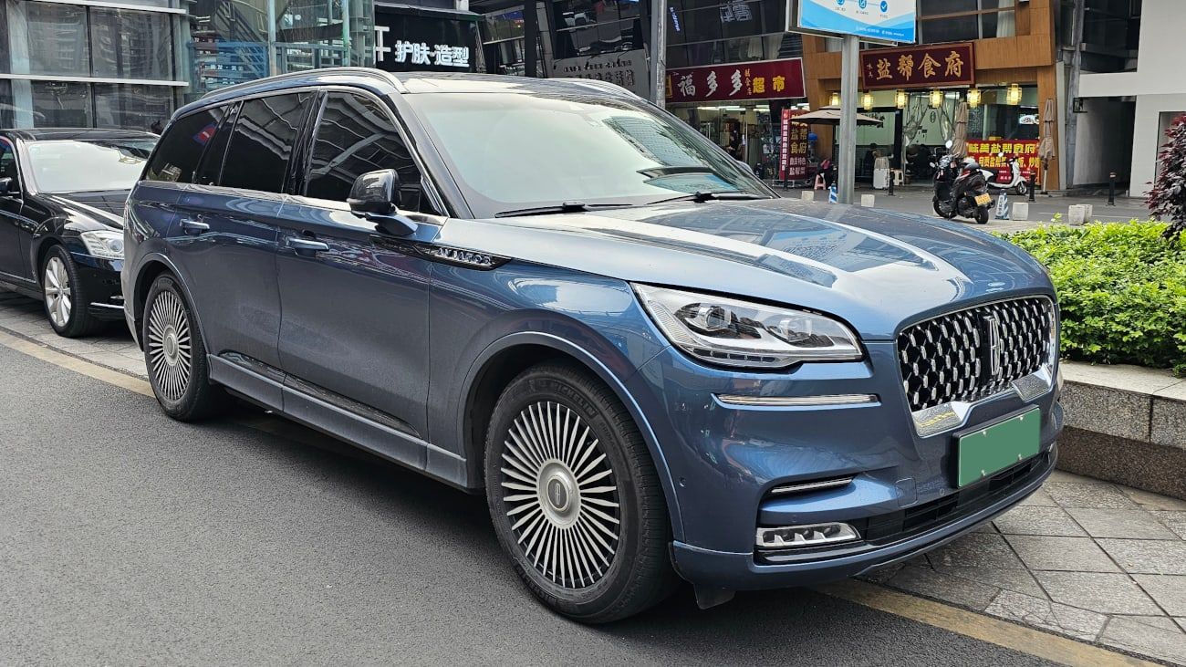 Blue-grey Lincoln Aviator plug-in hybrid, front three-quarter view on a street in China