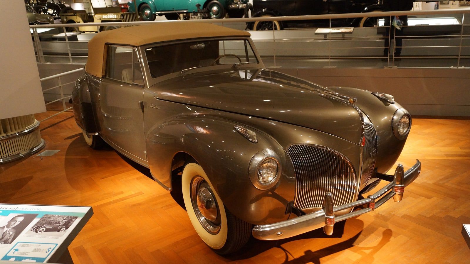 Gold 1941 Lincoln Continental cabriolet, front three-quarter view on museum display