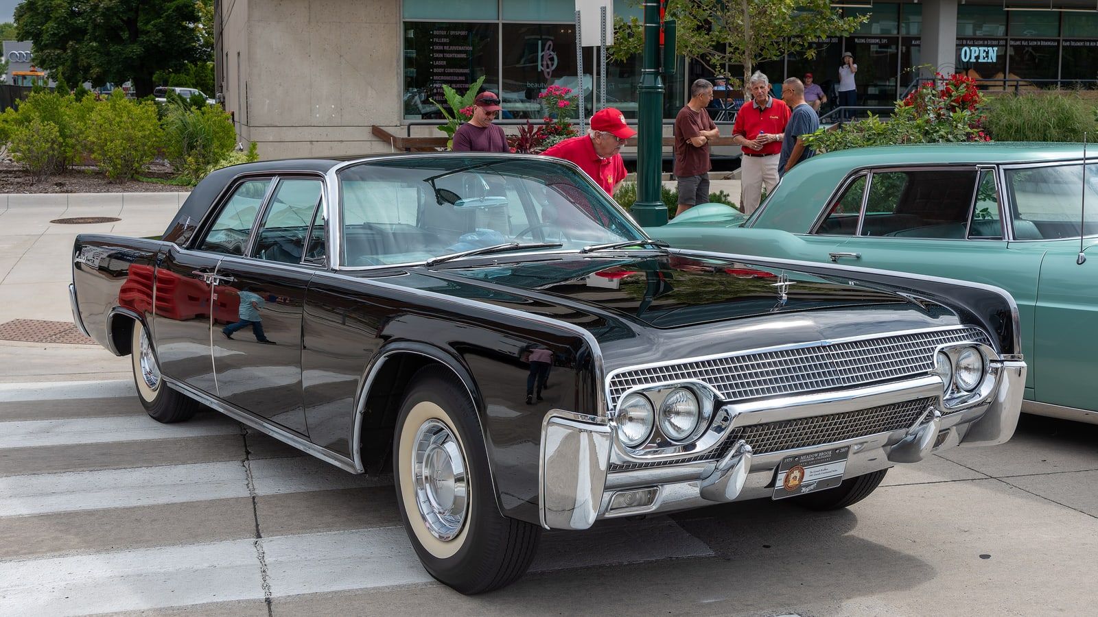 Black 1961 Lincoln Continental four-door sedan, front three-quarter view on a street