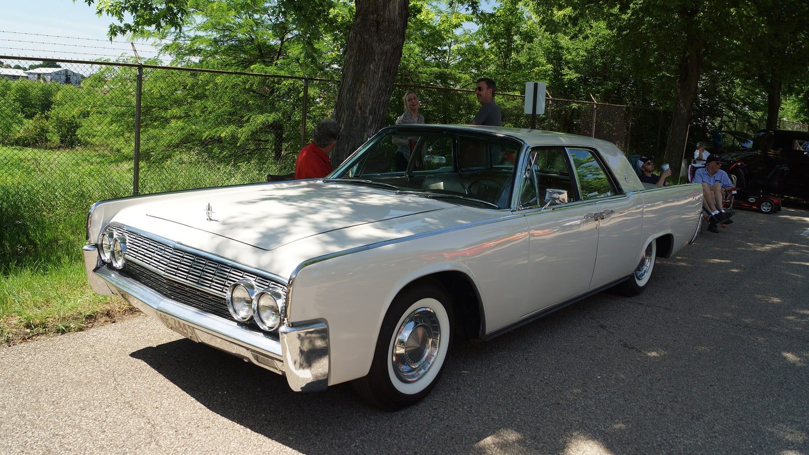 White 1962 Lincoln Continental four-door sedan, front three-quarter view on pavement
