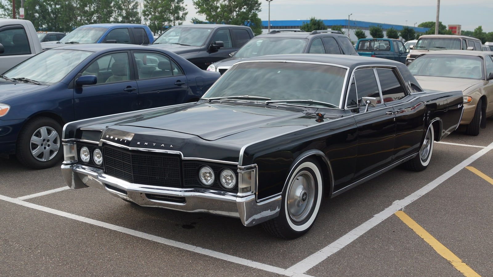 Black 1969 Lincoln Continental sedan, front three-quarter view in a parking lot