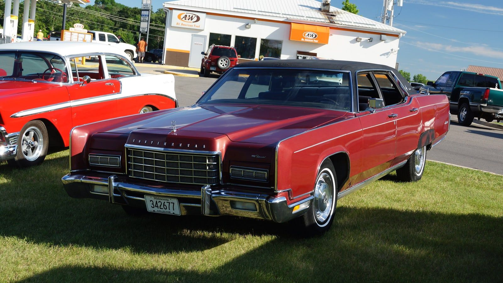 Red 1972 Lincoln Continental Town Car sedan, front three-quarter view at a filling station