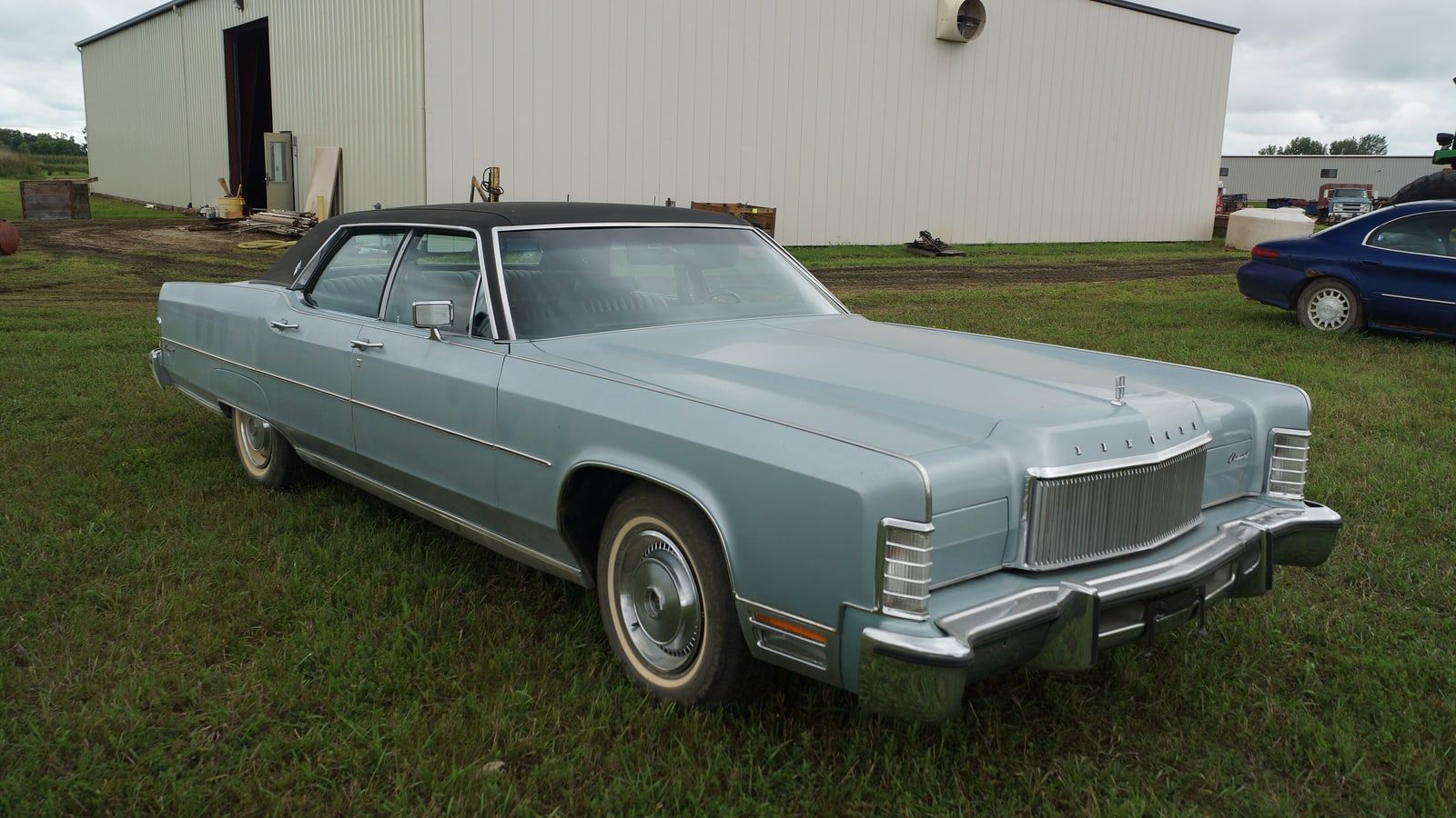 Light blue 1974 Lincoln Continental sedan, front three-quarter view on grass