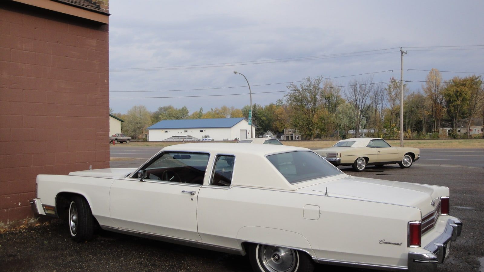 White 1975 Lincoln Continental coupe, front three-quarter view on a paved lot