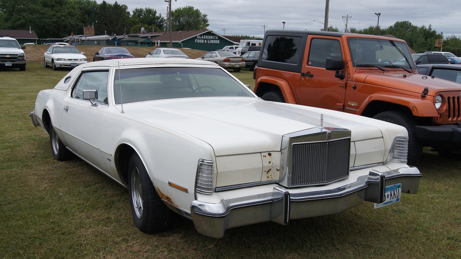 White 1976 Lincoln Continental Mark IV coupe, front three-quarter view on grass
