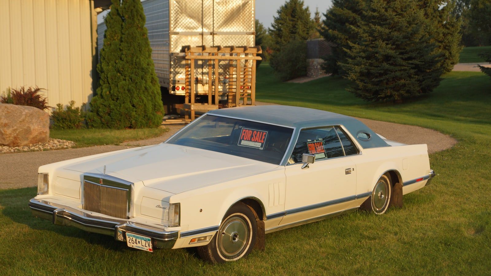 Cream 1977 Lincoln Continental Mark V coupe, front three-quarter view on grass