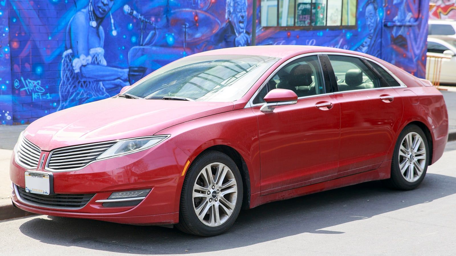 Red 2014 Lincoln MKZ AWD, front three-quarter view against a painted mural