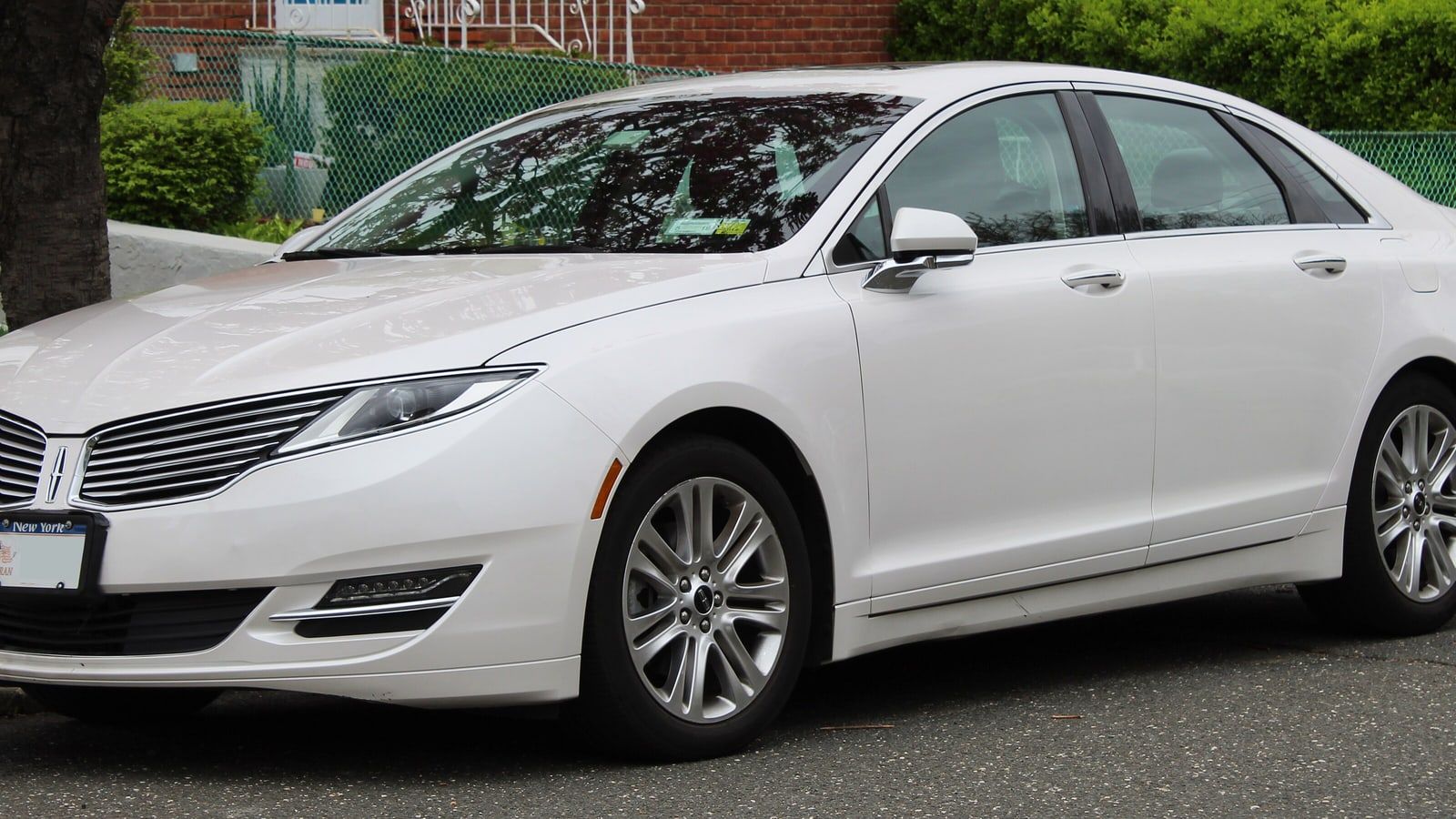 White 2016 Lincoln MKZ, front three-quarter view on a street