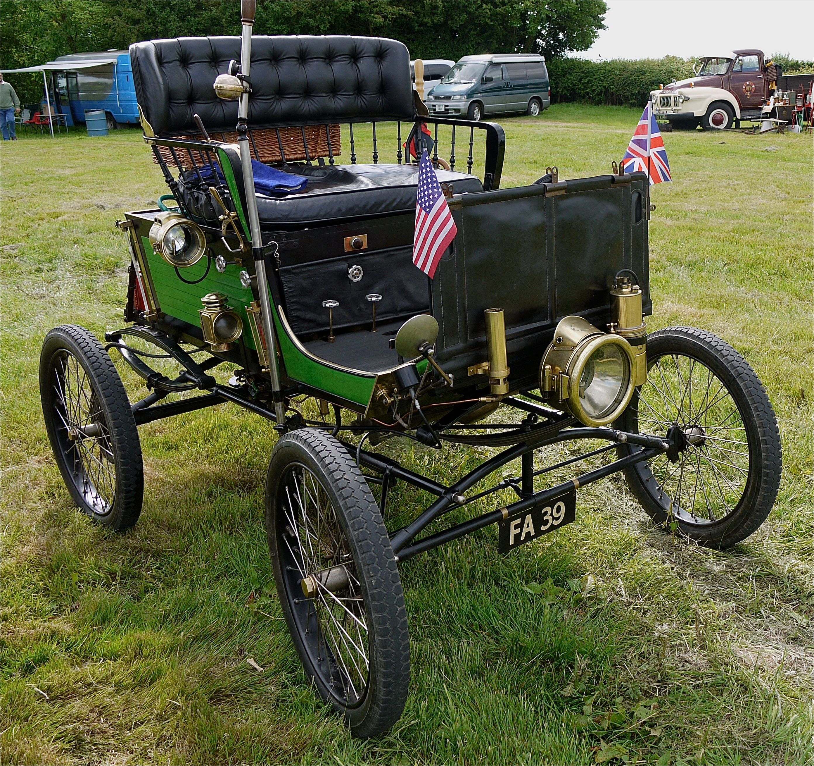 Green 1900 Locomobile steam runabout with brass lamps, front three-quarter view