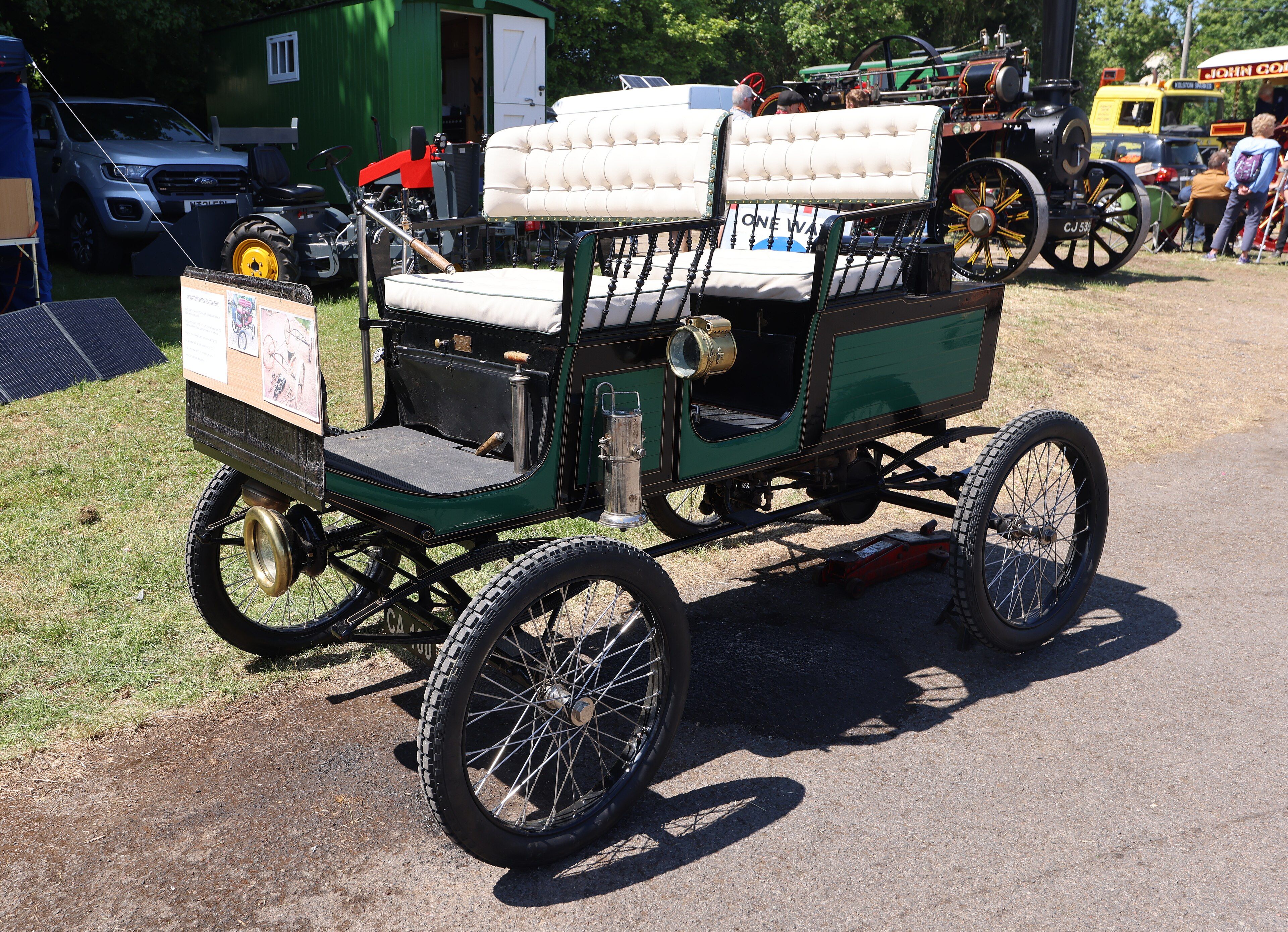 Green 1902 Locomobile steam surrey with tufted seats, front three-quarter view