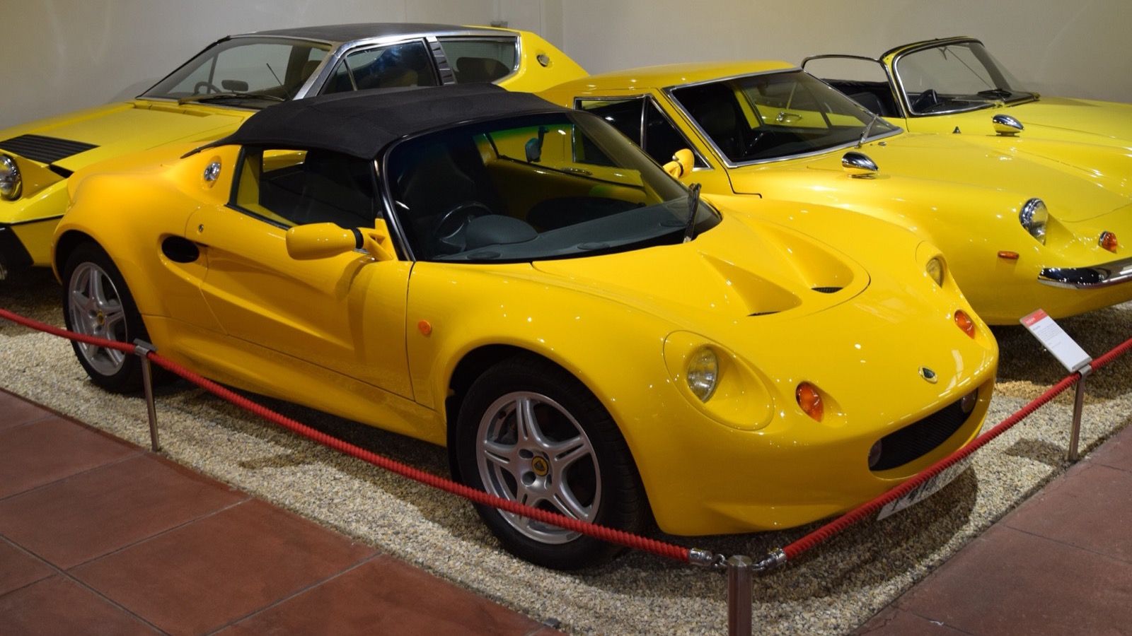 Yellow 1996 Lotus Elise Series 1 on museum display, front three-quarter view.