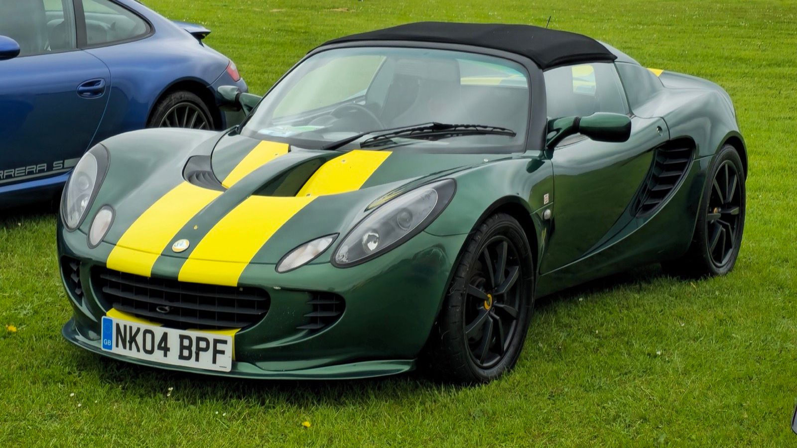 Green 2004 Lotus Elise 111S with yellow stripes, front three-quarter view.