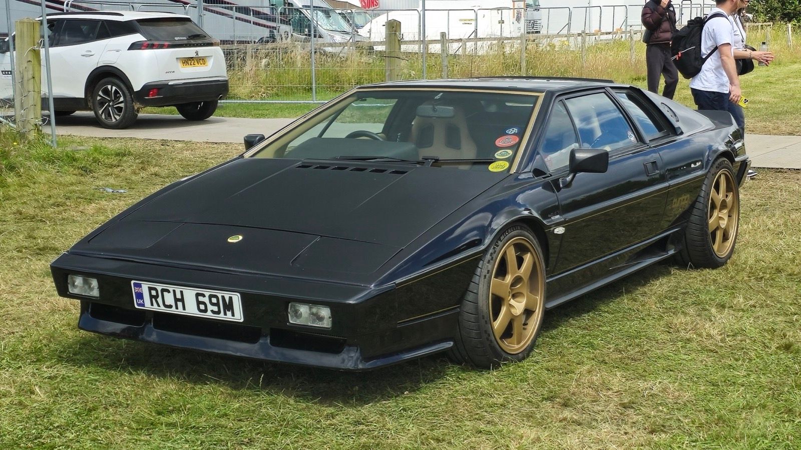 Black 1985 Lotus Esprit Turbo with gold wheels, front three-quarter view.