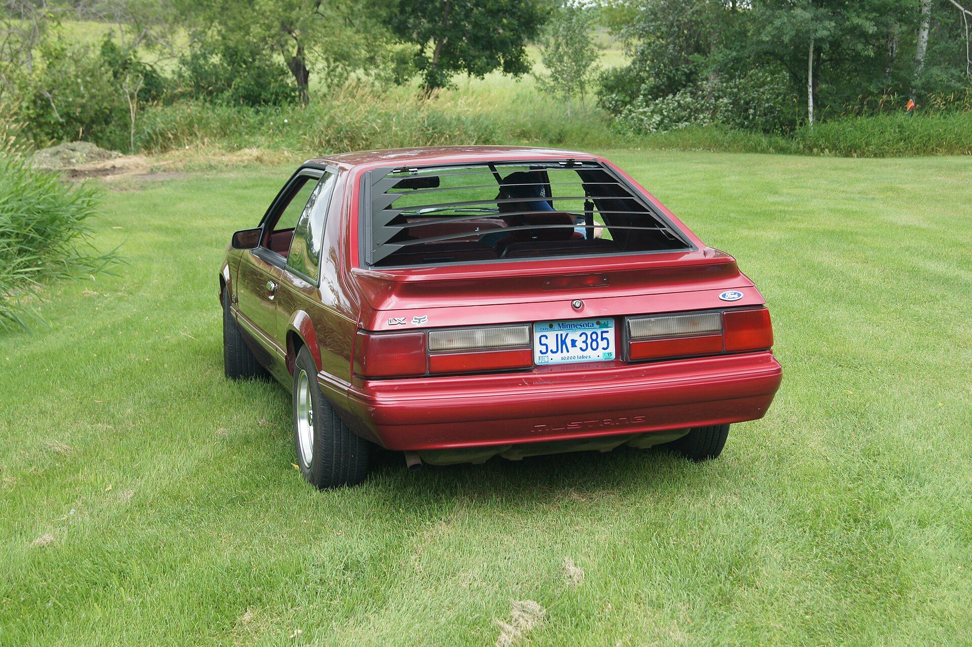 Red 1993 Ford Mustang LX 5.0 hatchback photographed from the rear left