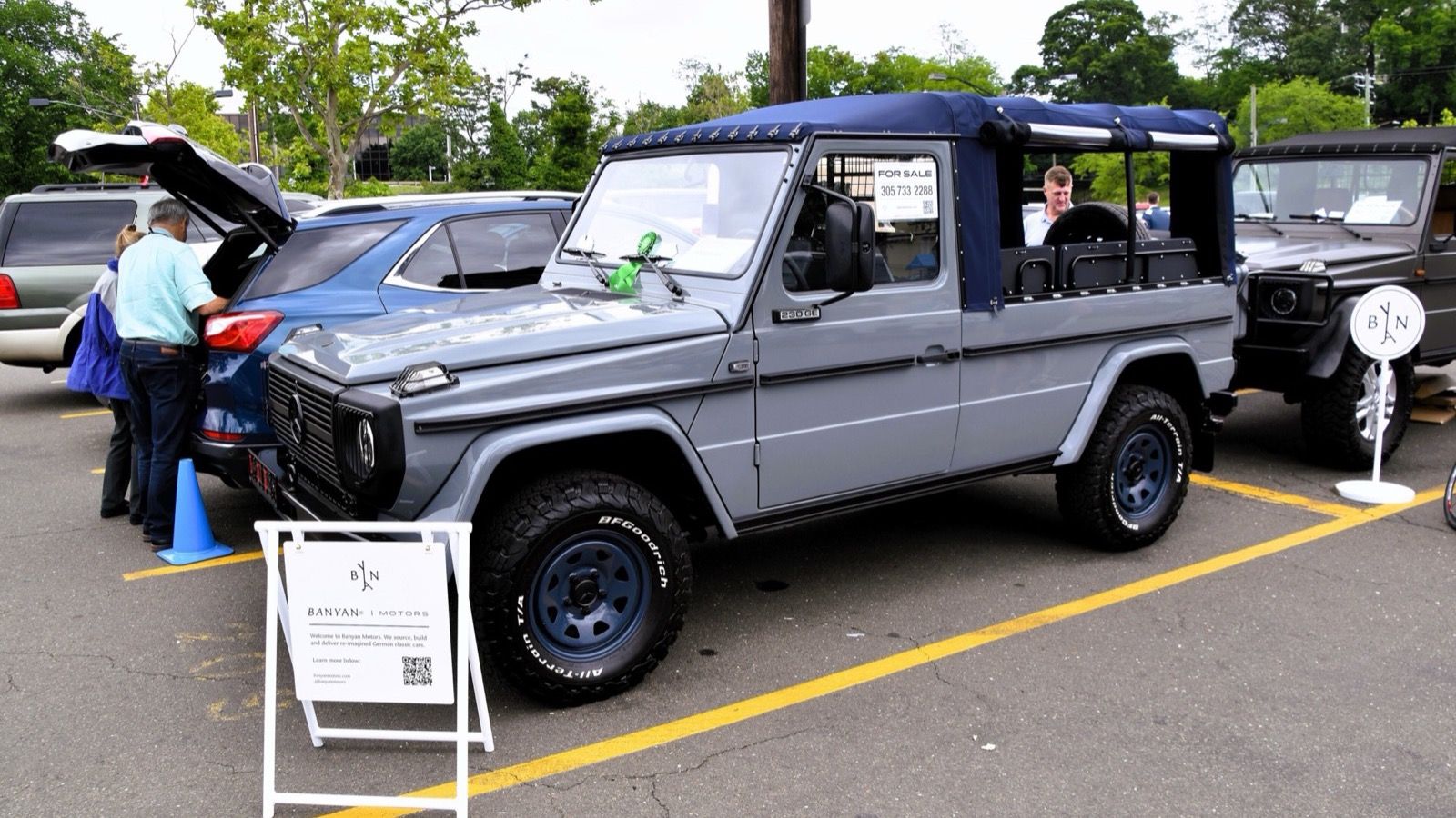 Grey 1991 Mercedes-Benz G-Class W460 230 GE soft-top at a car show, front three-quarter view