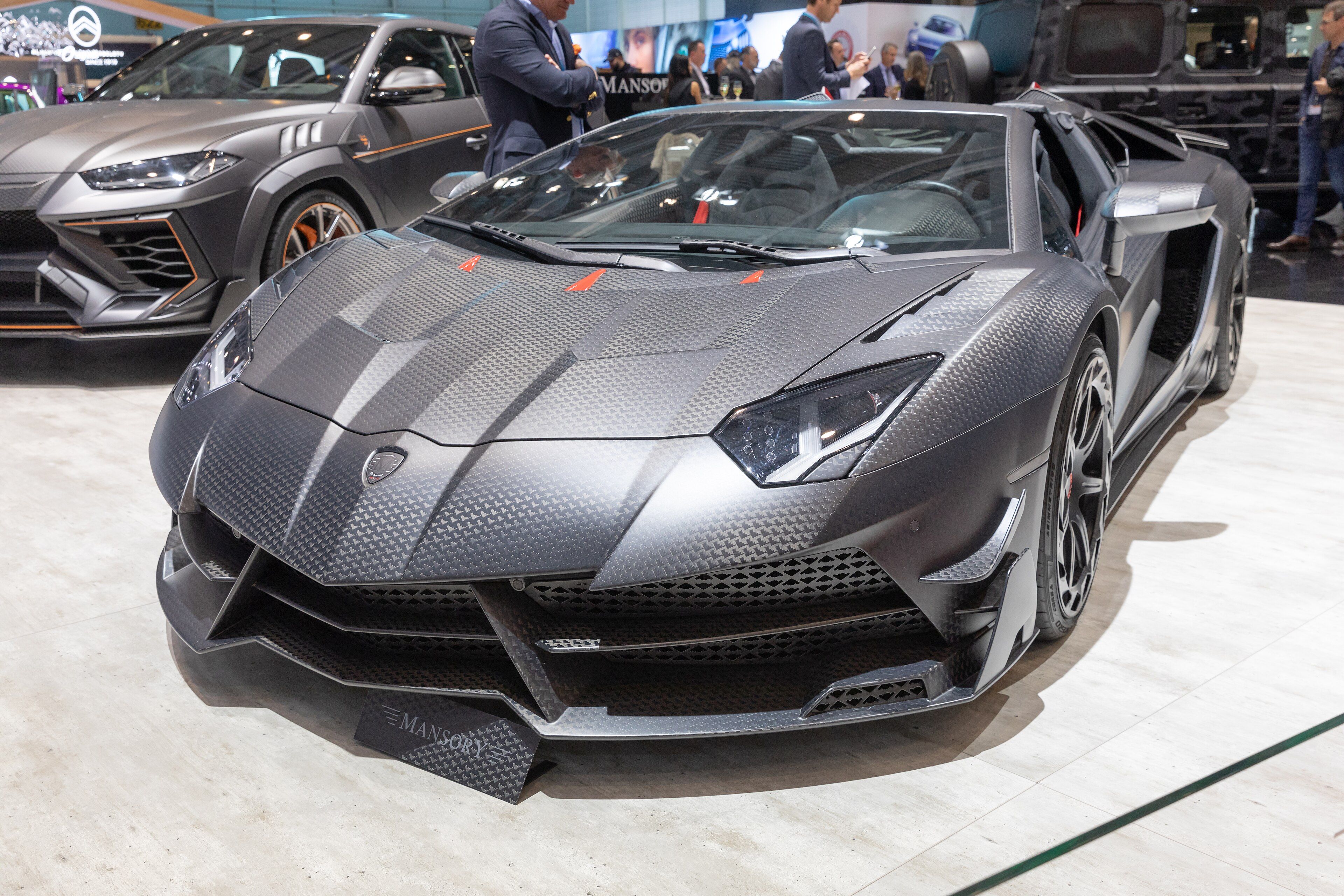 Bare carbon-fibre Mansory Carbonado EVO on the Lamborghini Aventador at the 2019 Geneva show, front three-quarter view