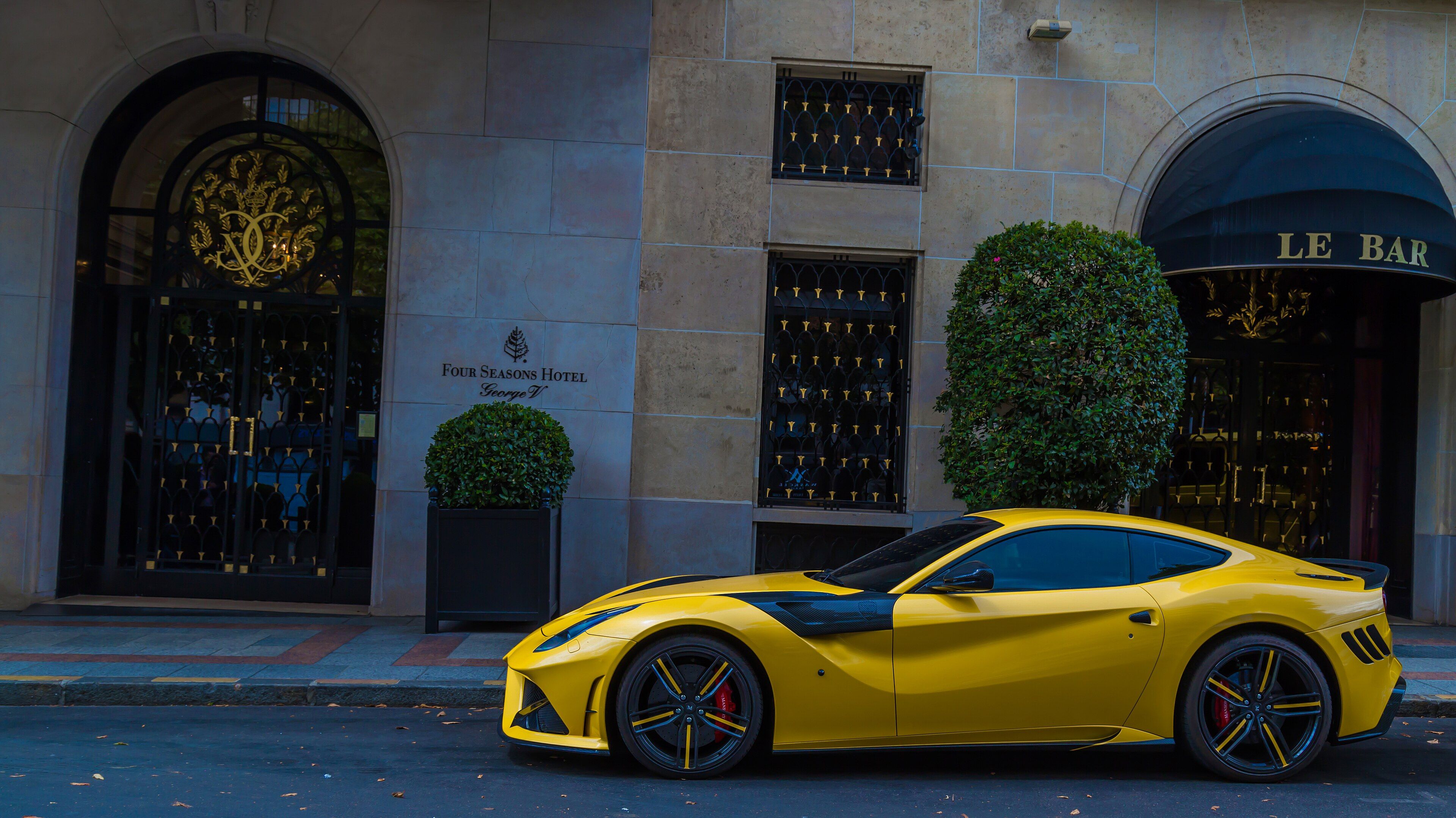 Yellow Mansory carbon-accented Ferrari F12 Berlinetta parked in Paris, side profile