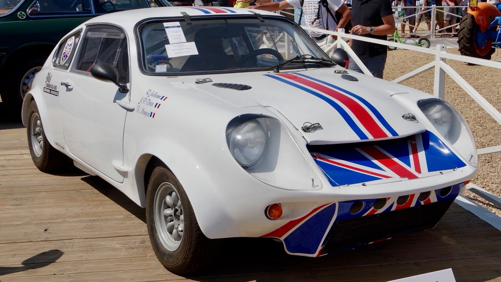 White 1966 Mini Marcos GT 1300 with red and blue stripes, front three-quarter view