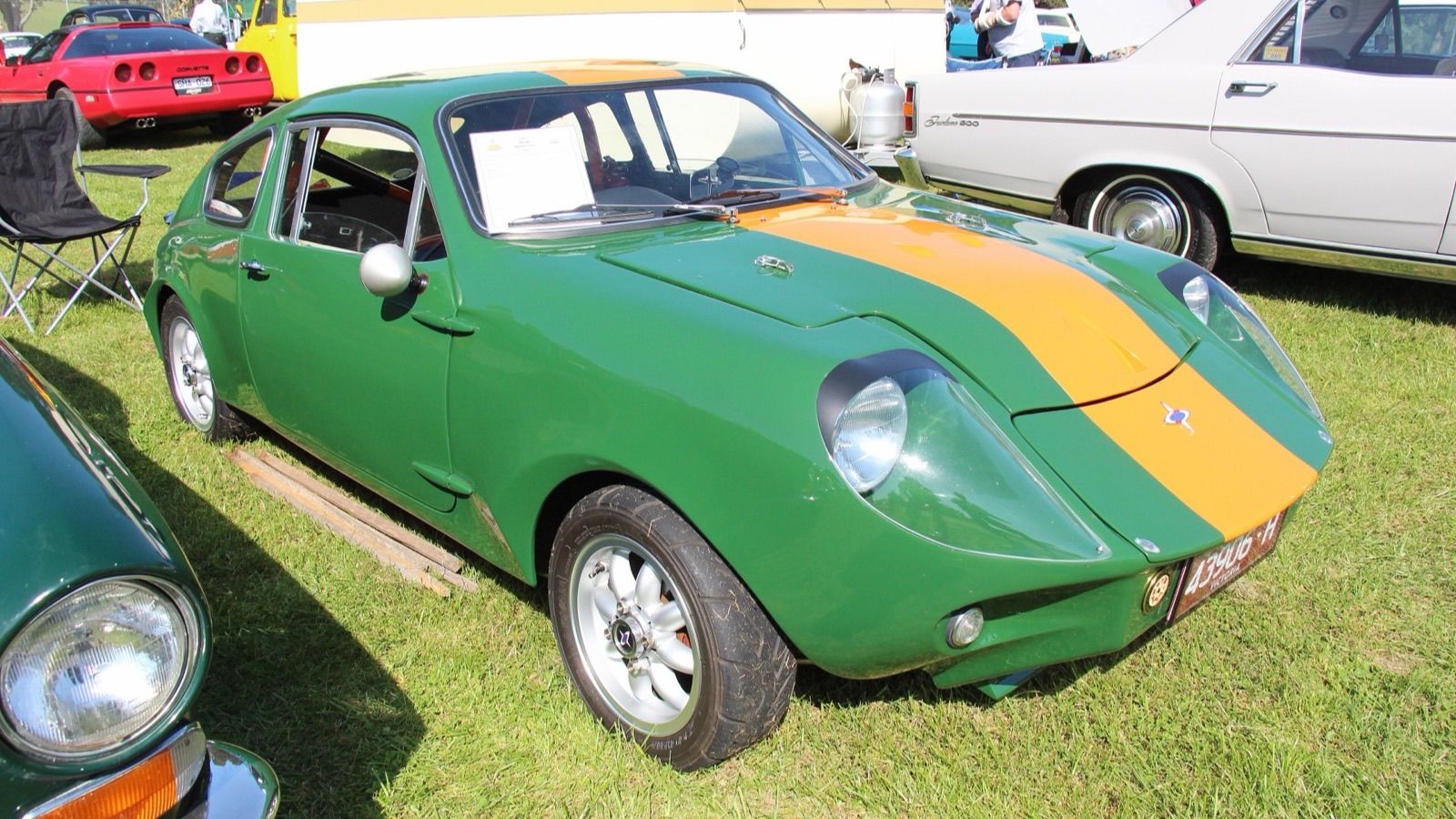 Green 1967 Mini Marcos GT with yellow centre stripe, front three-quarter view