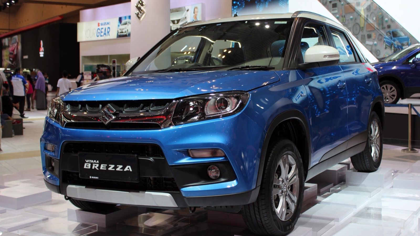 Blue 2016 Suzuki Vitara Brezza ZDi+ on a motor-show stand, front three-quarter view