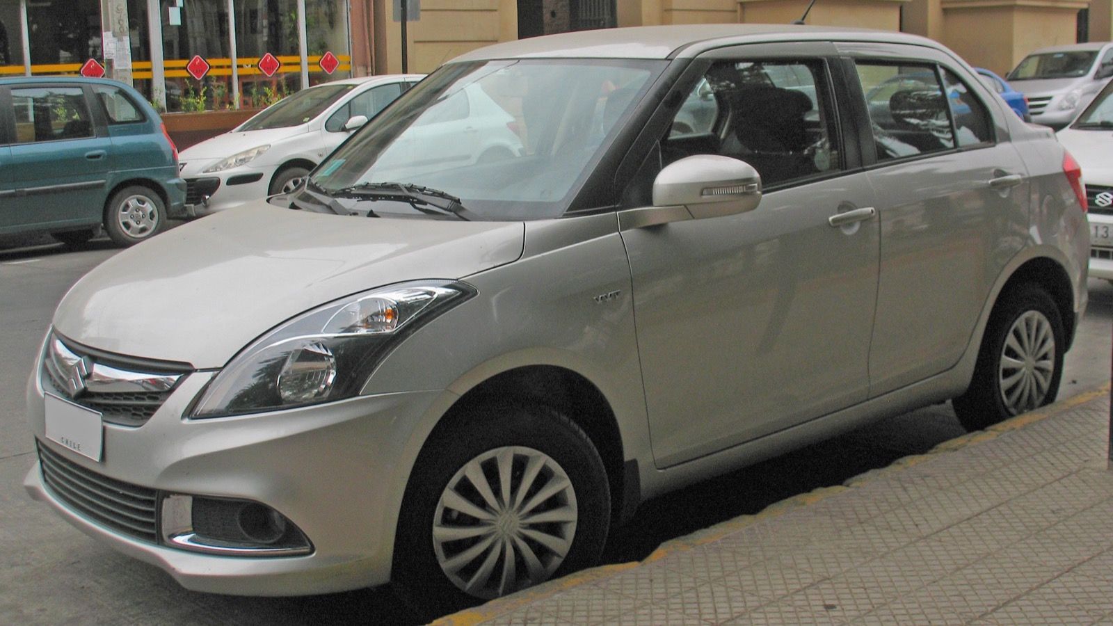 Silver 2016 Suzuki Swift Dzire compact sedan, front three-quarter view