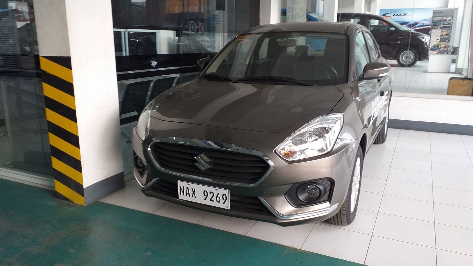 Bronze 2019 Suzuki Dzire compact sedan, front three-quarter view