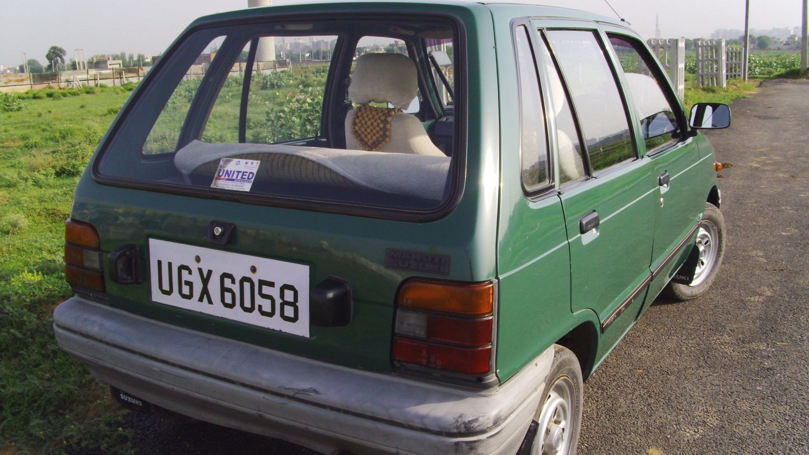 Green 1987 facelift Maruti 800 hatchback, rear three-quarter view