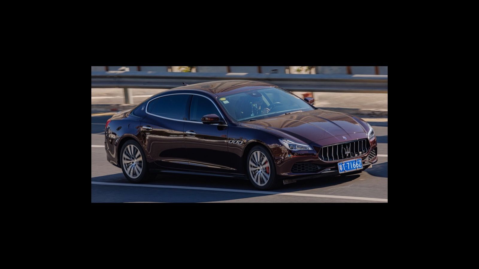 Dark-red sixth-generation Maserati Quattroporte (M156) sedan, front three-quarter view