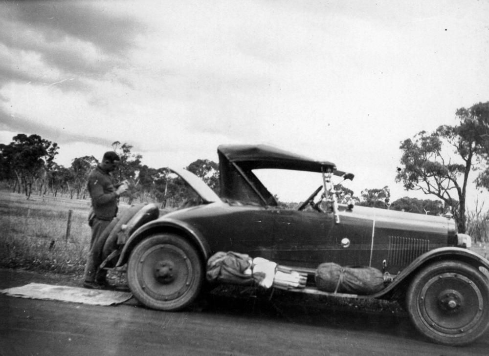 Period photograph of a man beside his 1925 Maxwell roadster, side profile