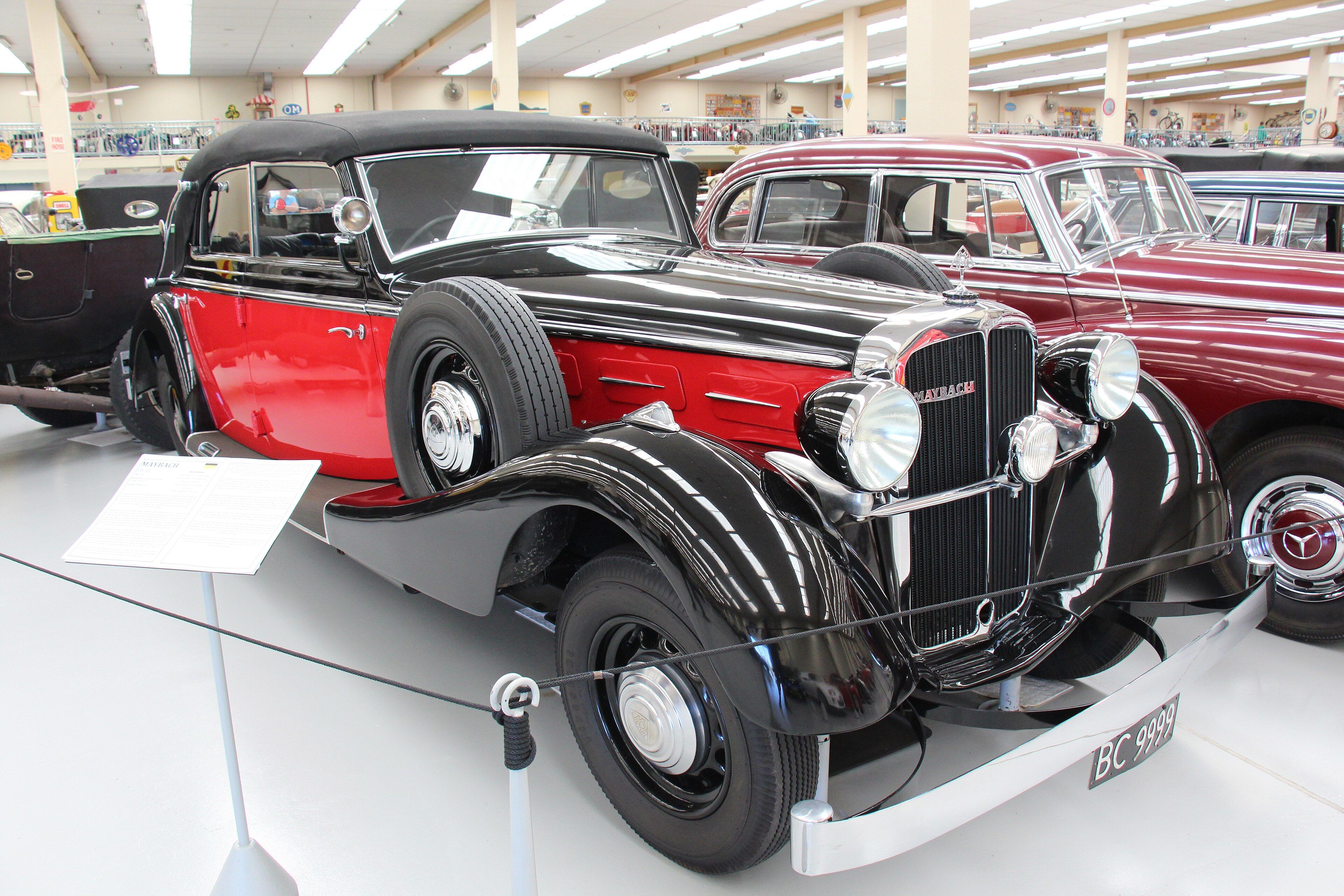 Black and red 1938 Maybach SW38 cabriolet on museum display, front three-quarter view