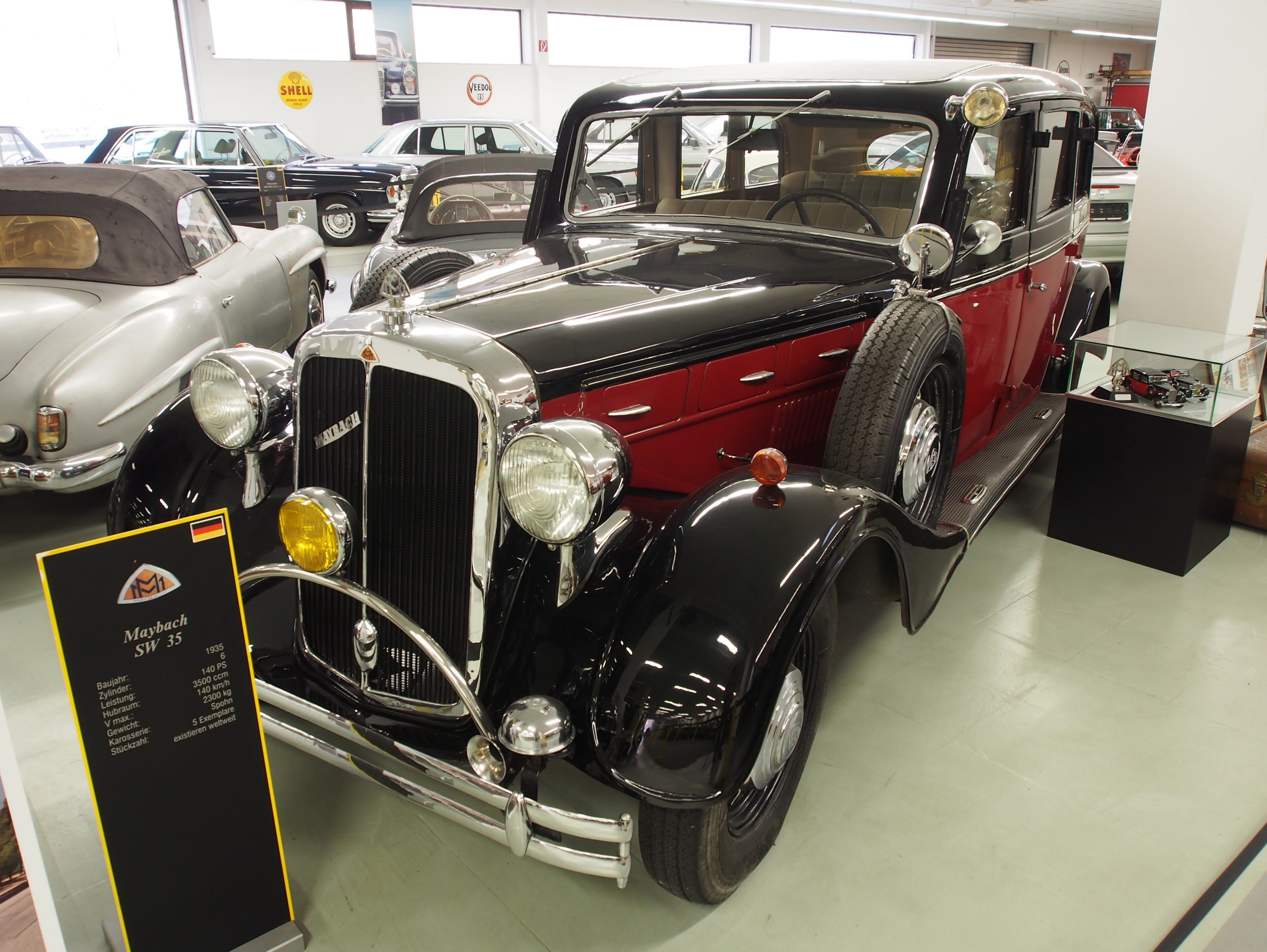 Black and red 1935 Maybach SW35 saloon on museum display, front three-quarter view
