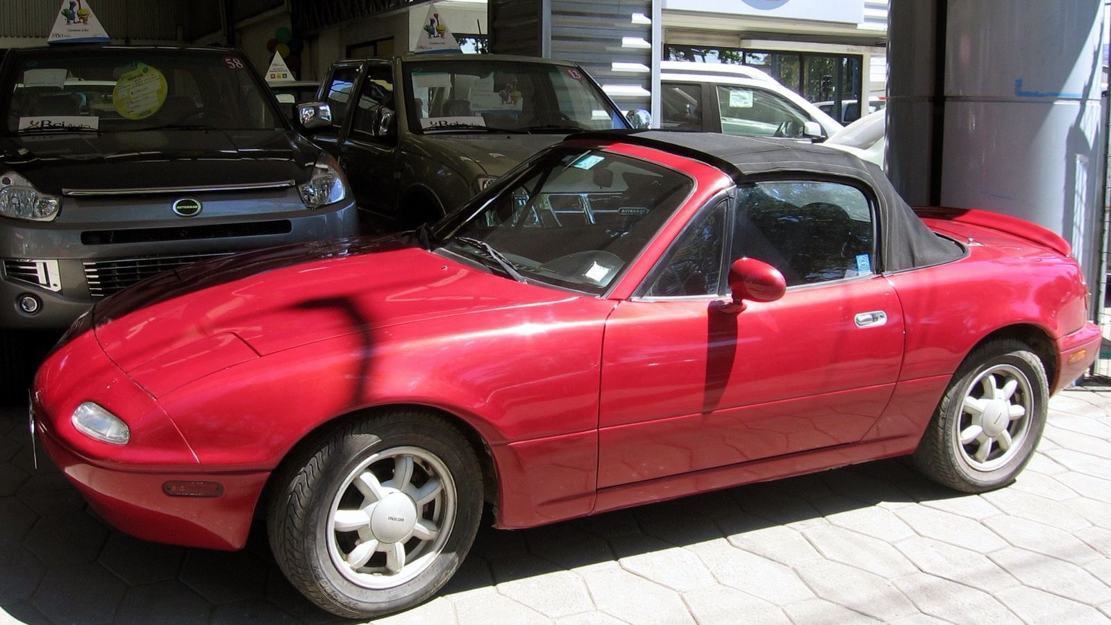 1996 Mazda MX-5 Miata, NA first generation — red roadster, front three-quarter view