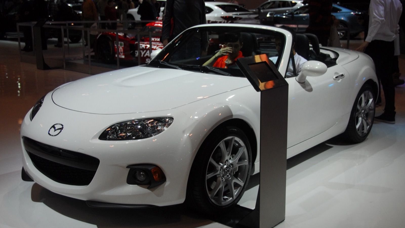 2014 Mazda MX-5 Miata, NC third generation — red roadster at an auto show, front three-quarter view