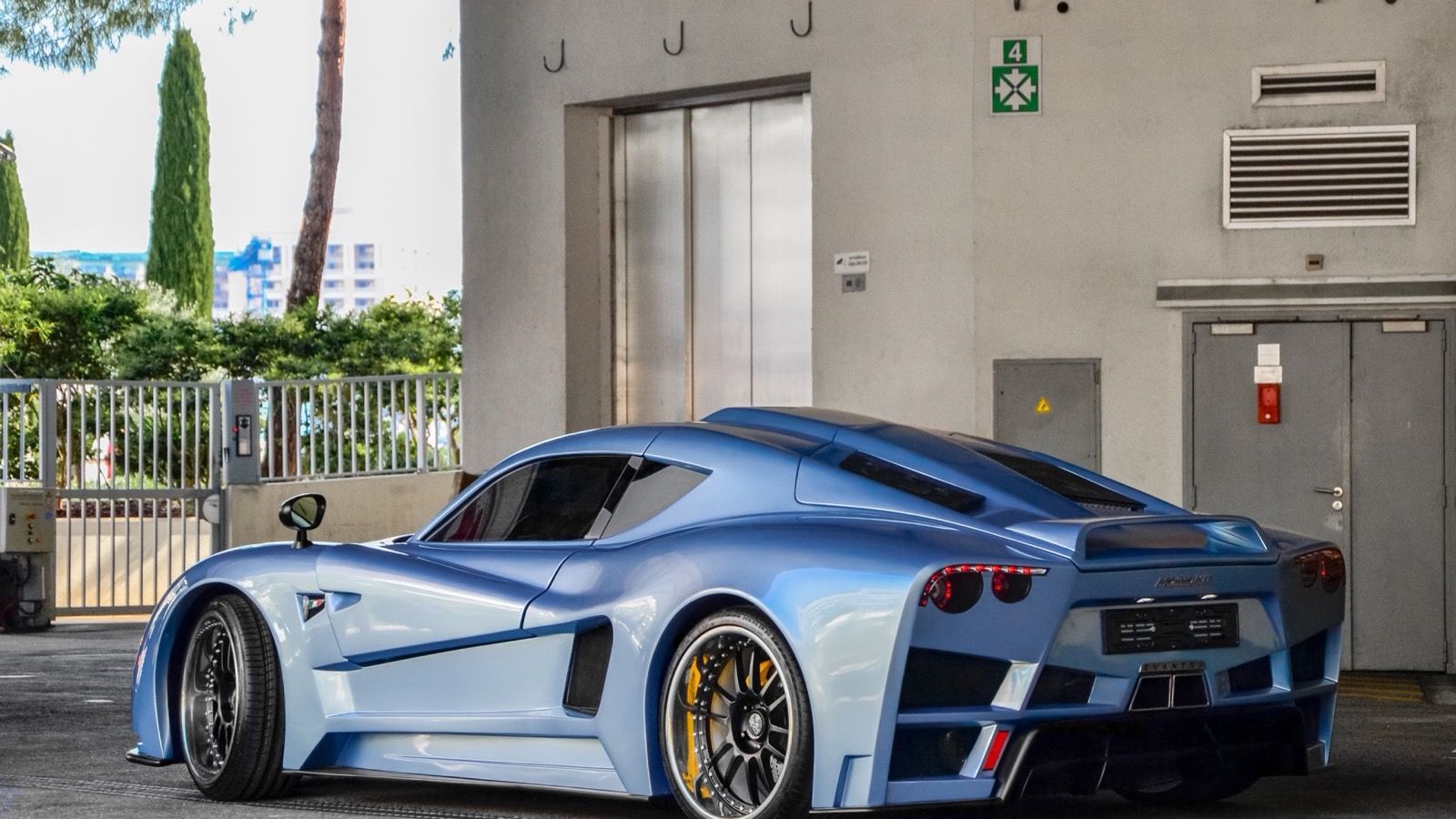 Light-blue Mazzanti Evantra coupe, rear three-quarter view