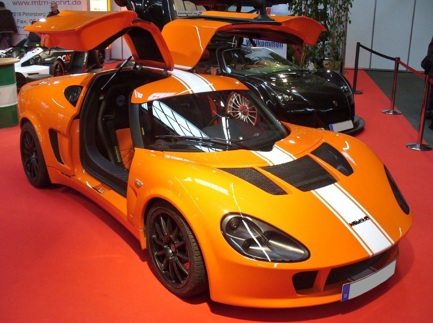 Orange Melkus RS 2000 coupe with open gullwing doors, front three-quarter view